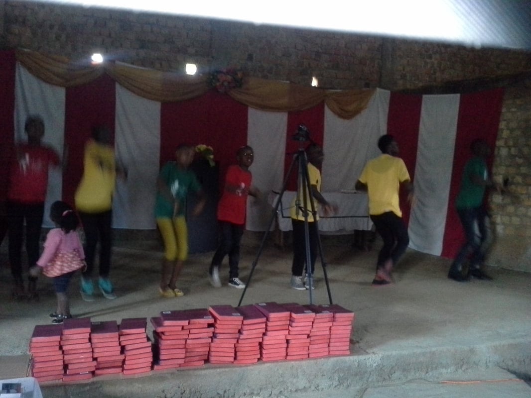 Children dancing beside Bible stacks at Zion, 2017.