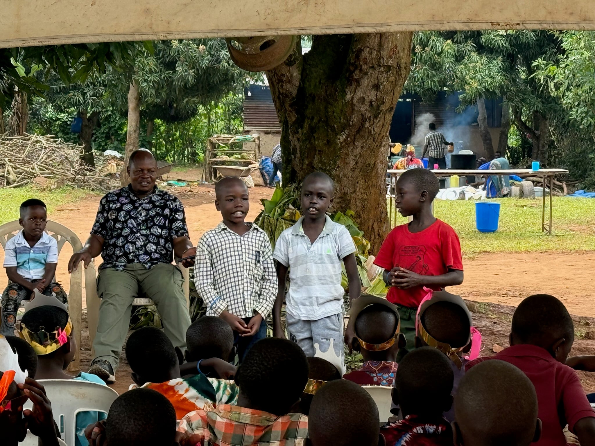 Boys presenting under a tent, 2025.