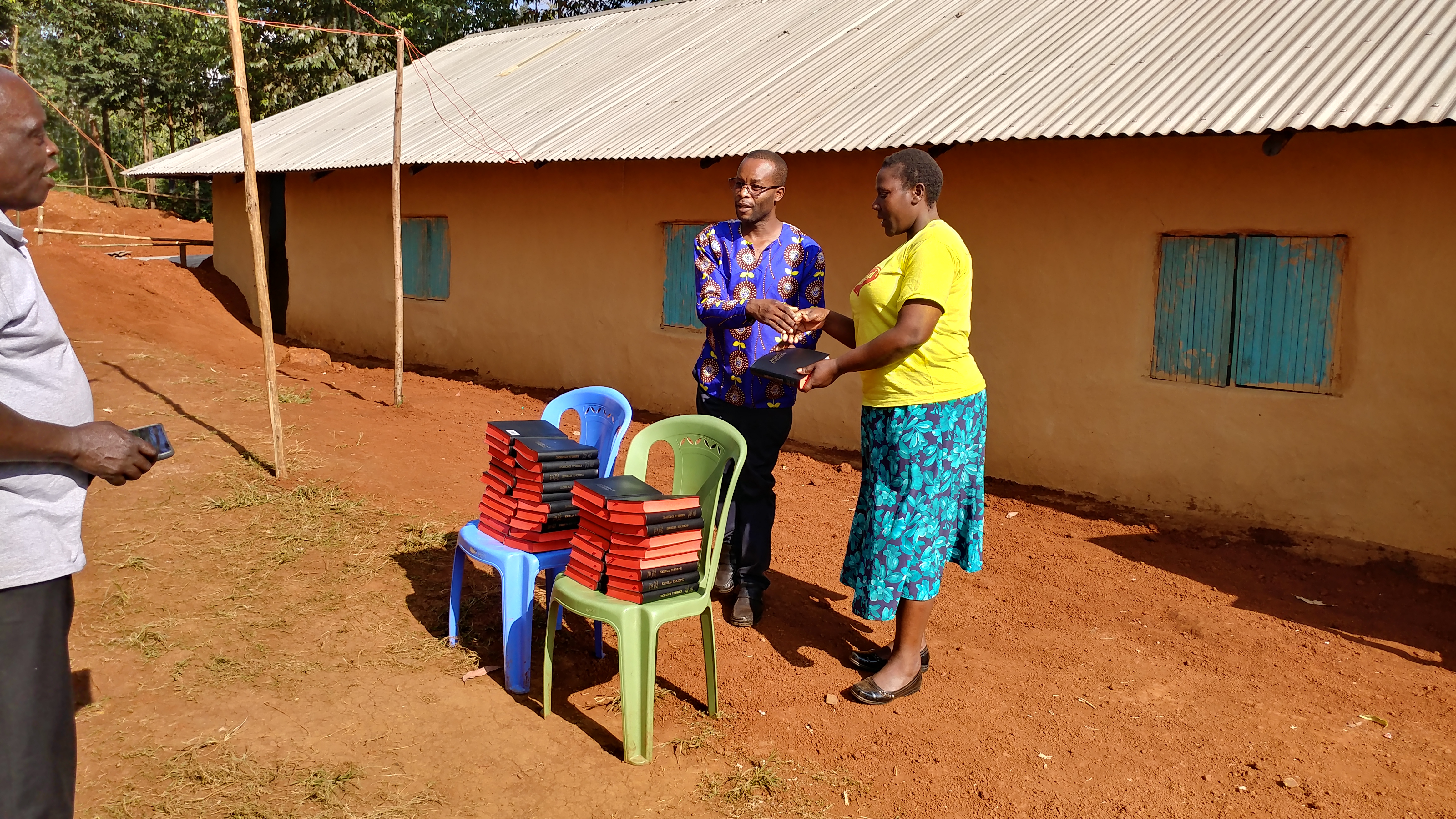 A Bible handed from the chair stacks to a woman at a Christian Restoration Church Partner Symposium, July 2019.