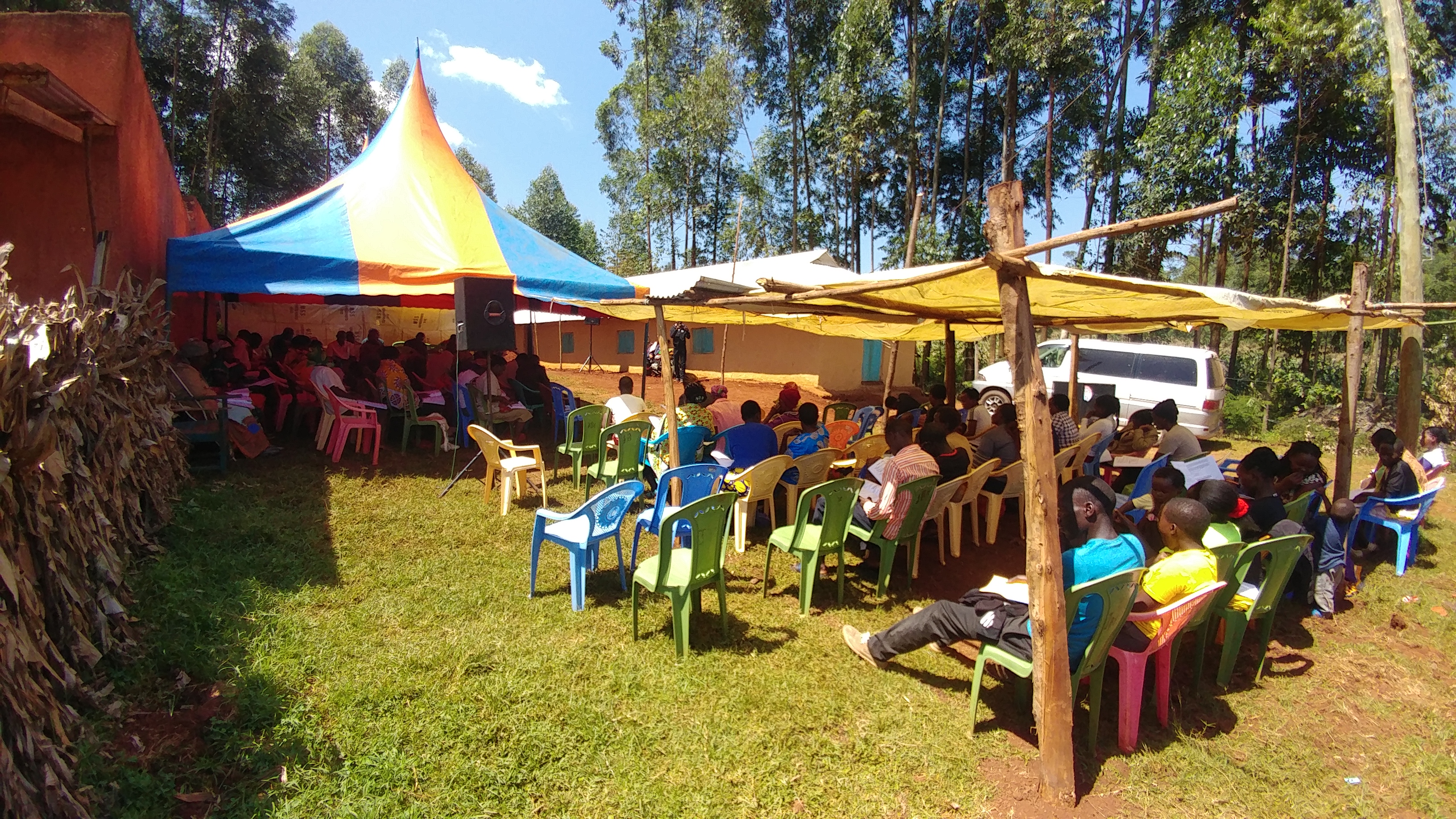 Hire tents and a yellow shade beside a peach classroom at a Christian Restoration Church Partner Symposium, July 2019.
