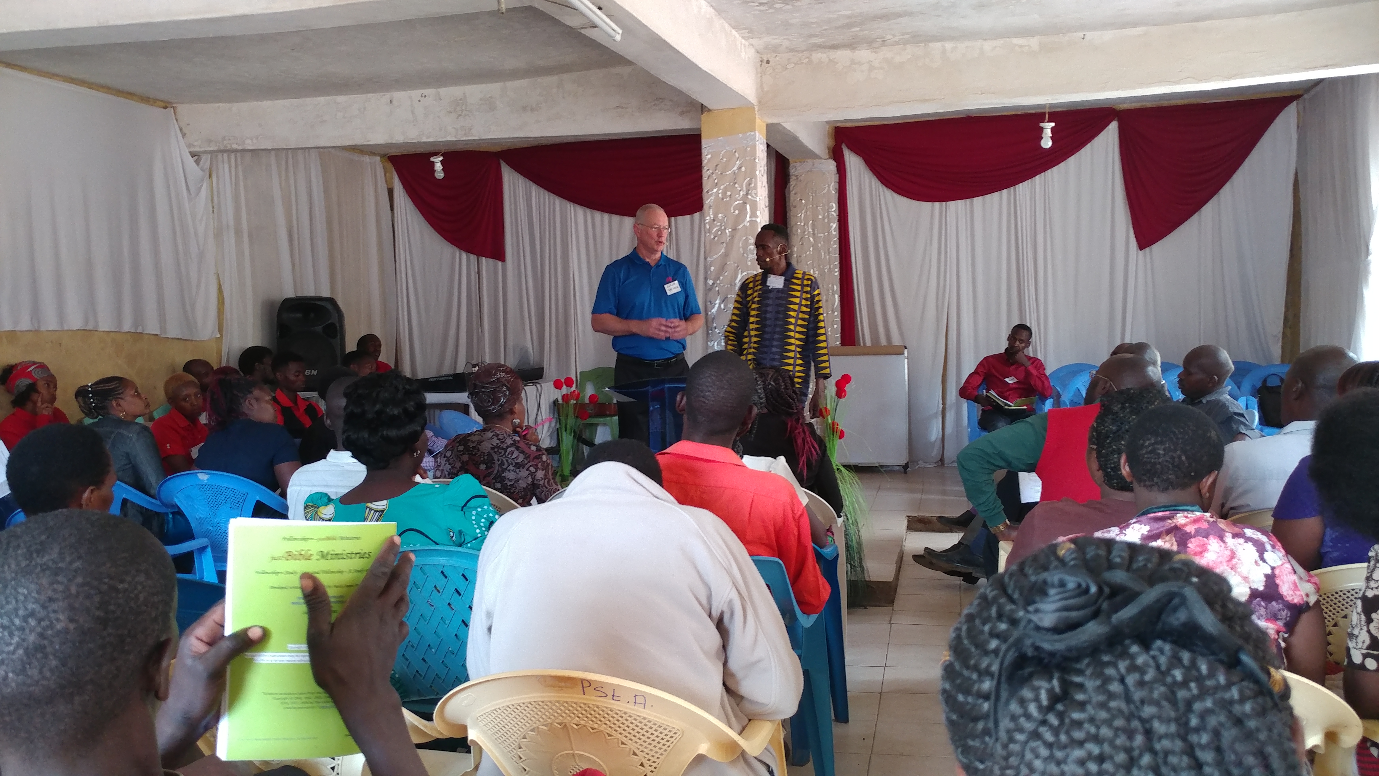 Lime-green workbook in the foreground while Mark teaches at CRC, Nairobi, 2019.