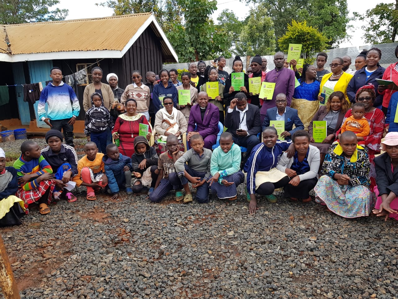 A Partner Symposium congregation in Kenya holding workbooks — the work that keeps going out from Nairobi.
