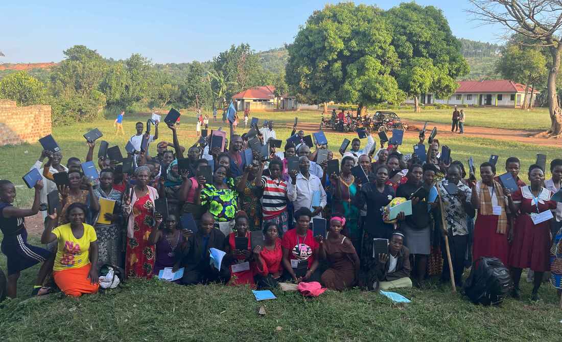 Pastors holding newly received Bibles at a symposium.