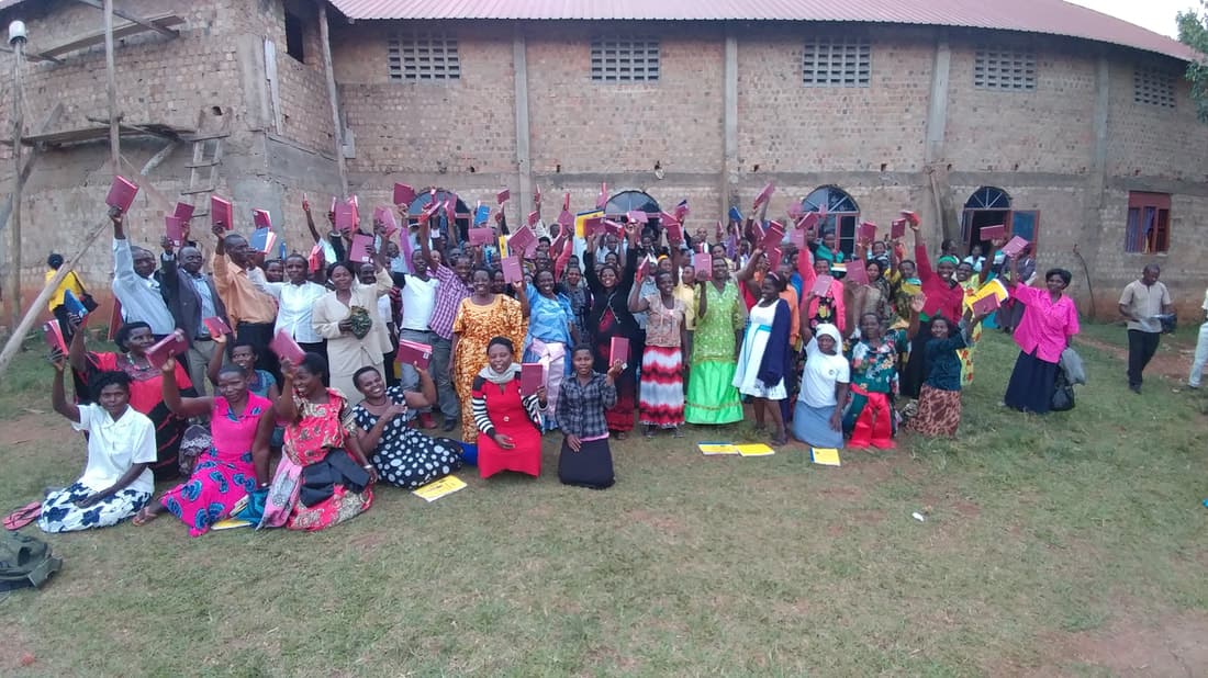 A gathering in Uganda holding up the Bibles they received.