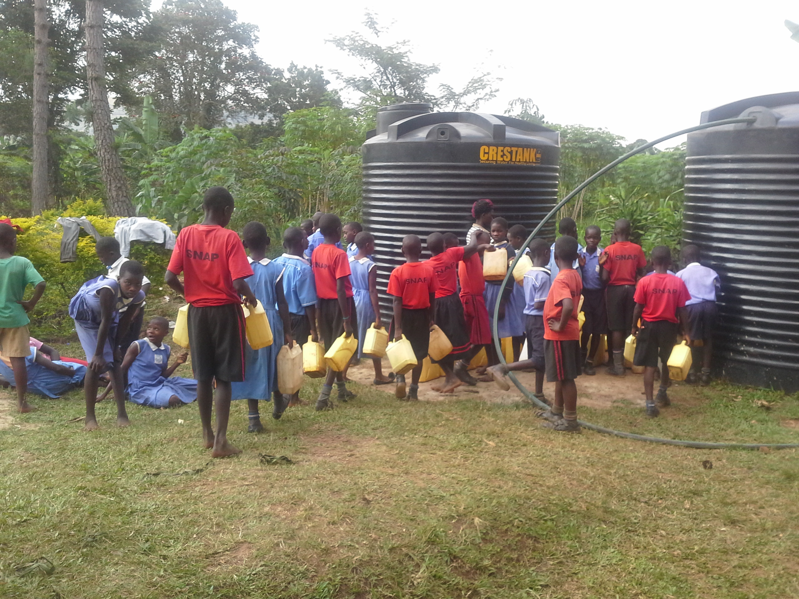 Schoolchildren with yellow jerry cans at the Zion water tanks, July 2017.
