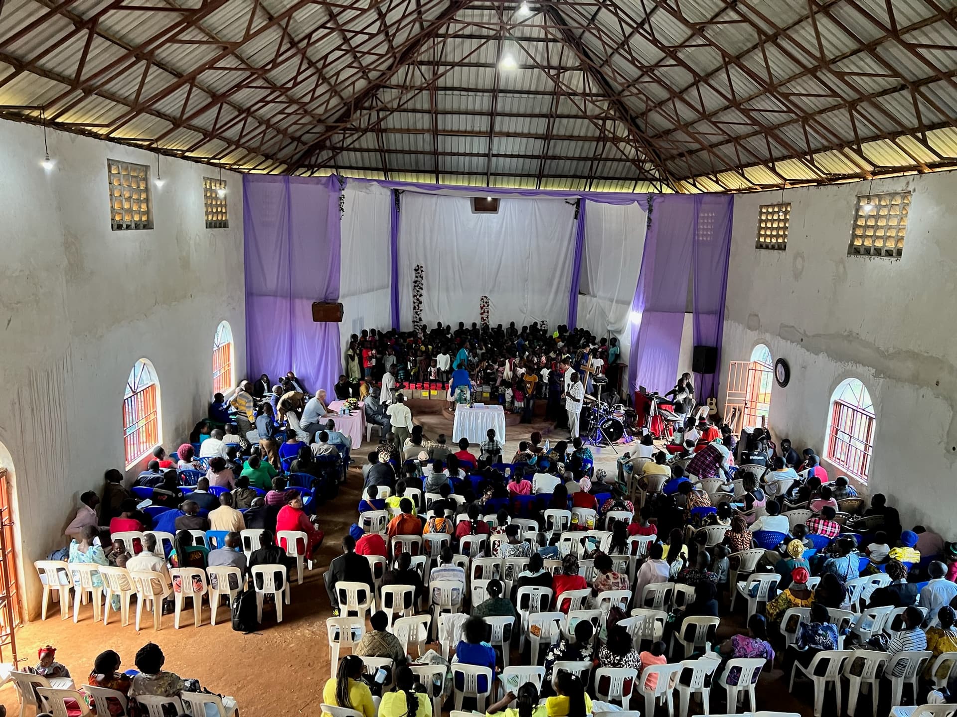 A packed symposium hall at the Zion Community Center, seen from the balcony.